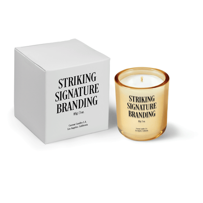 Glimmering gold 3 oz Mini Signature candle, printed, shown beside its gift box.