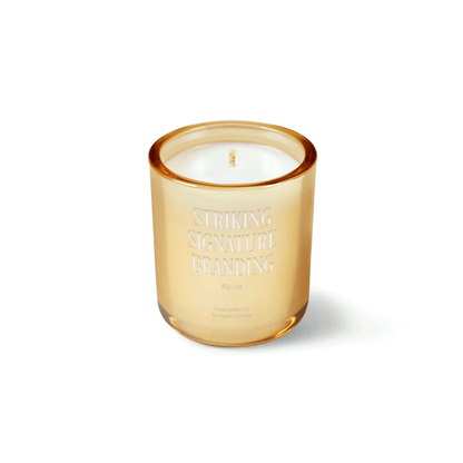 Glimmering gold 3 oz Mini Signature candle with a laser-engraved custom logo, shown on its own.