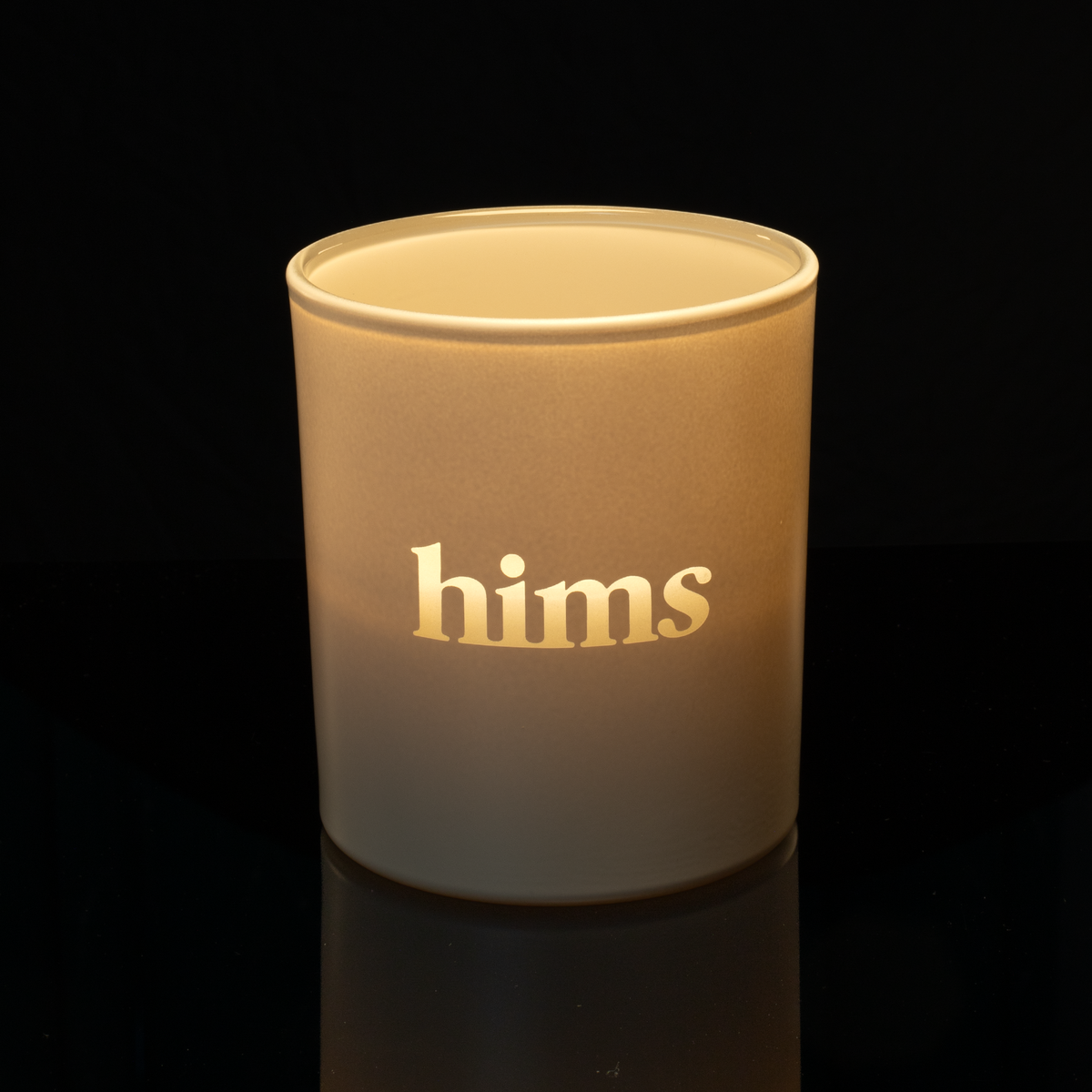 Nude 14 oz. Luxury Engraved Candle lit, shown on a black background.