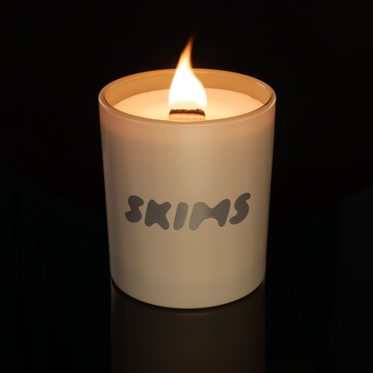 Nude 14 oz. Luxury Printed Candle lit, shown on a black background.