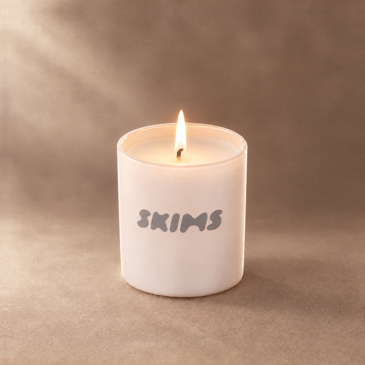 Nude 9 oz. Classic Printed Candle lit with a printed custom logo, shown on a matching nude background.
