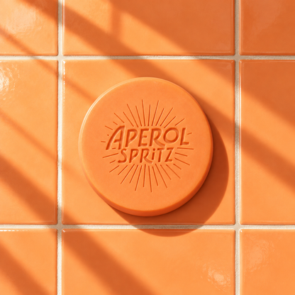 Orange round bar soap laser engraved with a brand logo, 3.6 oz