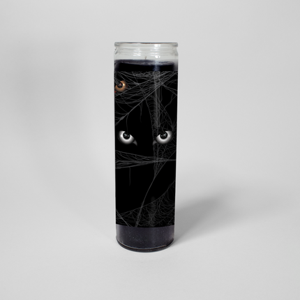 This Halloween-themed prayer candle from Custom Candles LA features a black jar with a spooky design. The text "Peter, Behave. Someone's always watching" is printed on the side of the candle, surrounded by images of spider webs and eyes. This is the Always Watching candle.