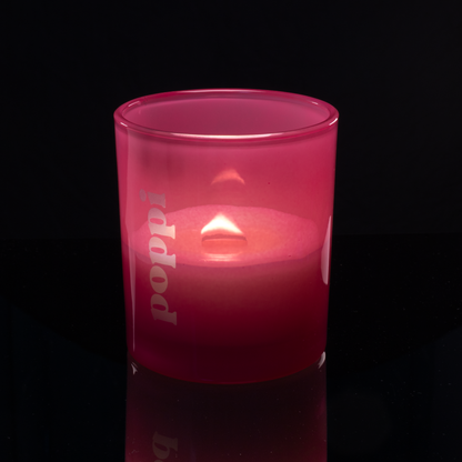 Pink 14 oz. Luxury Engraved Candle lit, shown on a black background.