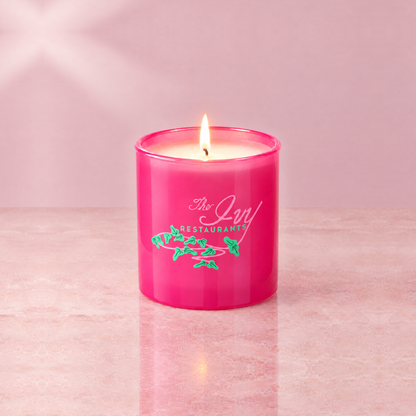 Pink 9 oz. Classic Printed Candle lit with a printed custom logo, shown on a matching pink background.