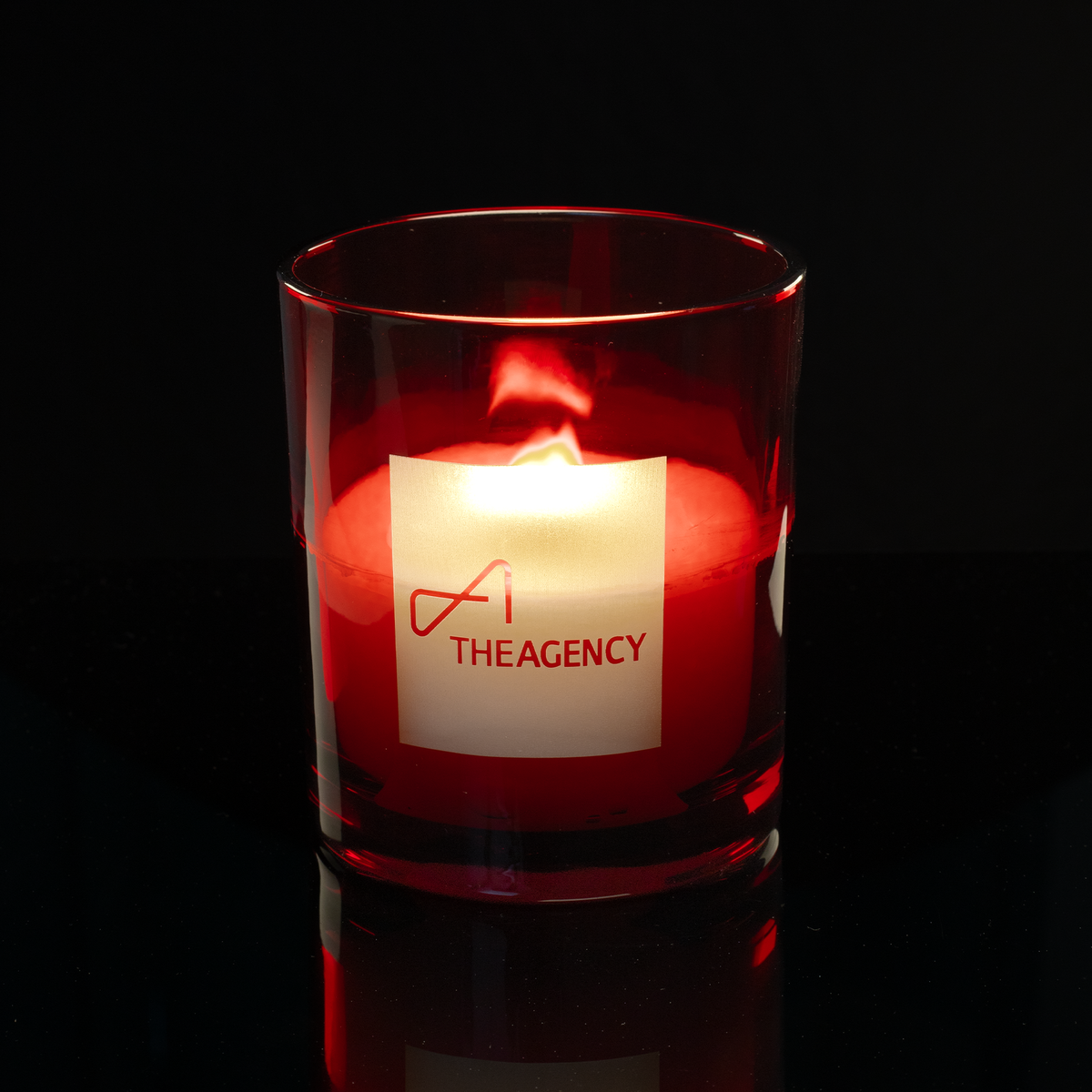 Red 14 oz. Luxury Engraved Candle lit, shown on a black background.