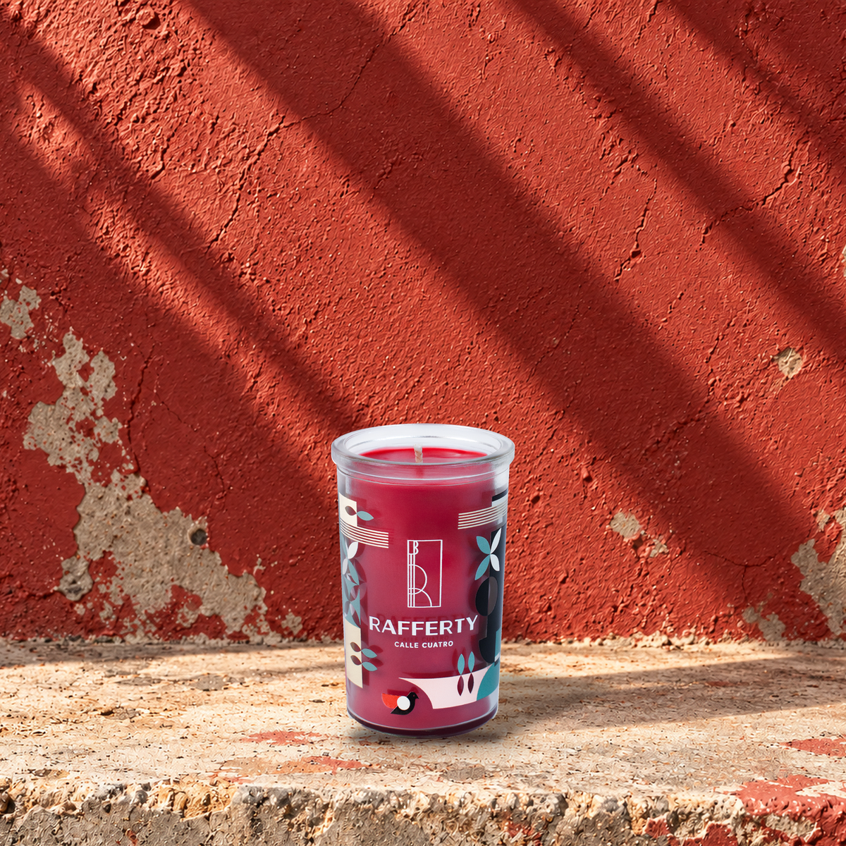 Red 5 oz custom mini prayer candle printed with the Rafferty logo on a red background, unlit