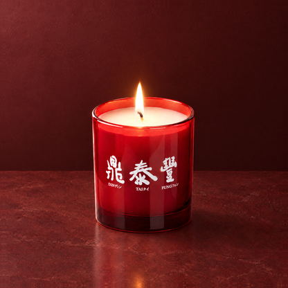 Red 9 oz. Classic Printed Candle lit with a printed custom logo, shown on a matching red background.