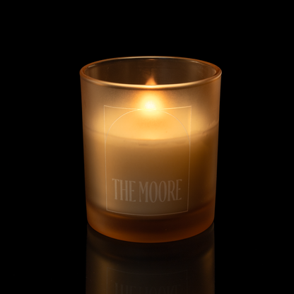 Sand 14 oz. Luxury Engraved Candle lit, shown on a black background.