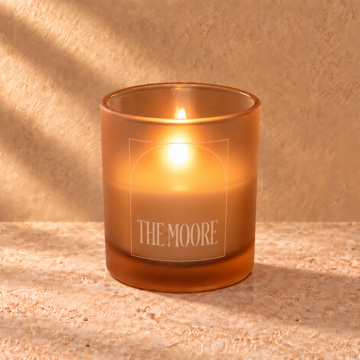Sand 9 oz. Classic Engraved Candle with a custom engraved logo, lit.
