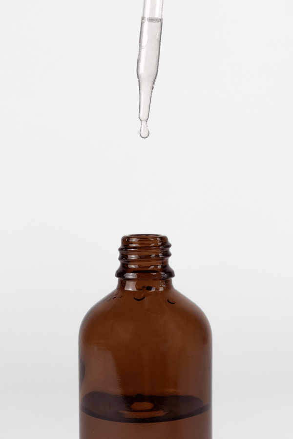 Brown glass bottle with dropper on a white background