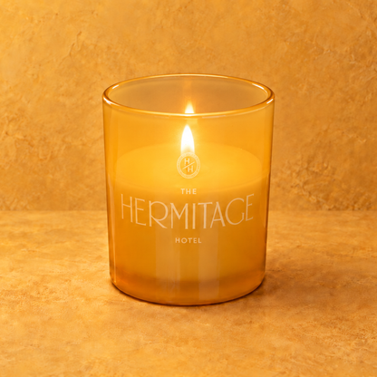 Yellow 9 oz. Classic Engraved Candle with a custom engraved logo, lit.