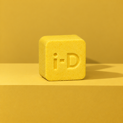 Yellow custom bath bomb with a debossed brand logo on a yellow backdrop, no foam