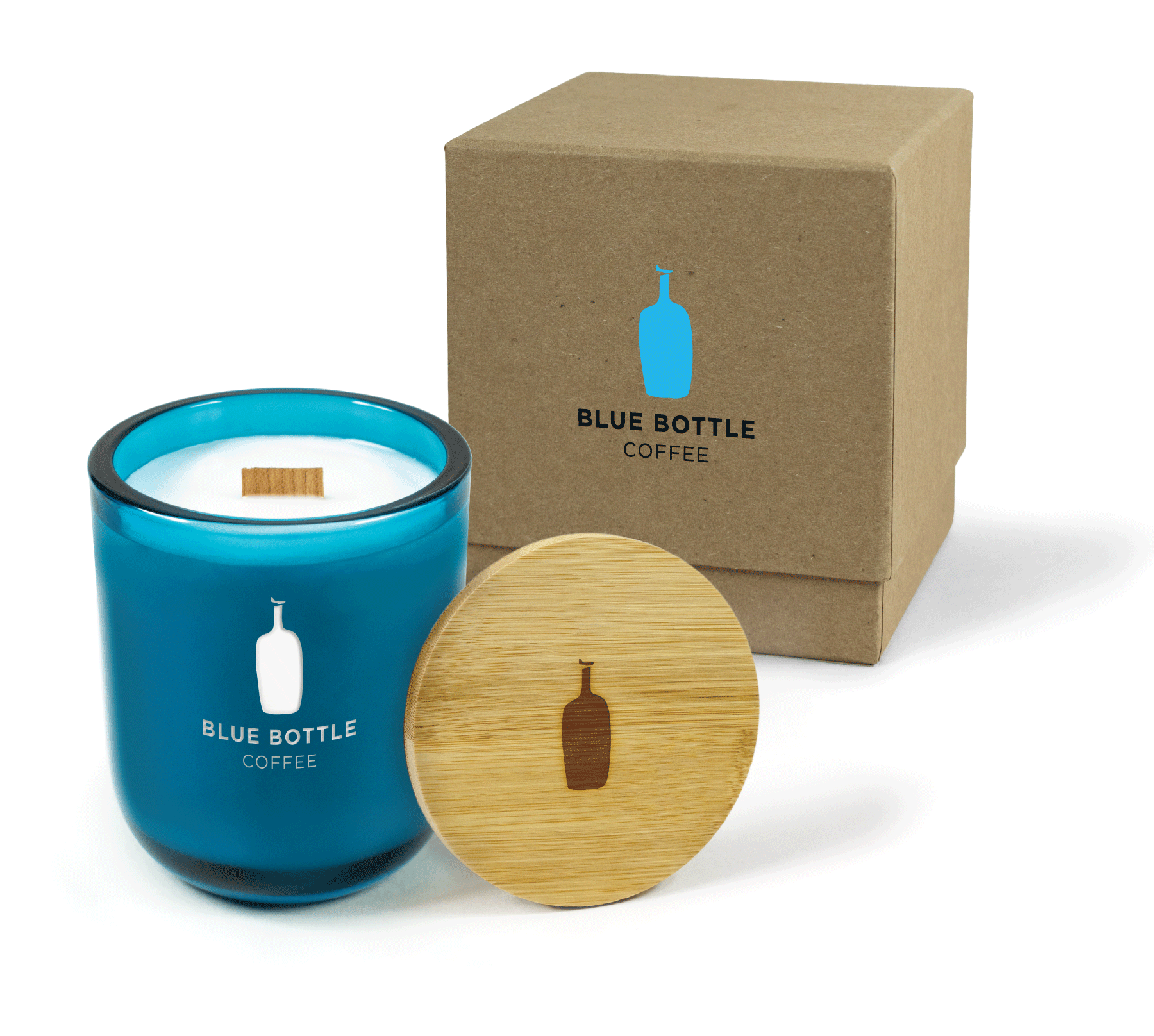 A 12 oz Luxe Custom Candle in the color “Oceania” which is a splashy teal from Custom Candles LA. The candle features a wood wick and a laser-engraved logo and bottle icon for “Blue Bottle Coffee” on the front of the glass allowing the white candle wax to show through. Leaning against the side of the candle is a bamboo candle lid engraved with the bottle icon. In the background, there is a kraft 2-piece box printed with a black and blue “Blue Bottle Coffee” logo and icon.