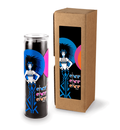 A 16 oz Prayer Candle from Custom Candles LA filled with black wax in a tall glass container. The candle is printed with an image on a woman with spiky hair and her hands on her hips in royal blue and white in front of a blue and a pink circle with the black wax showing through. Next to the woman the glass Is printed with the words "Exer exer the exer show" stacked in blue, pink, and orange. To the right of the candle sits a Kraft mailer box with a sticker on the box that is printed with the same label.