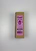 An unboxing video of the 16 oz Prayer Candle from Custom Candles LA filled with pink wax that comes in a Kraft mailer box with a pink sticker label of the logo artwork. The candle is printed with a logo that reads "KIVA LOST FARM PINK JESUS" in black. Printed in various pinks and black is imagery of a strawberry in a church like window surrounded by the logo and a silhouette of a farm. The pink wax shows through the imagery. 