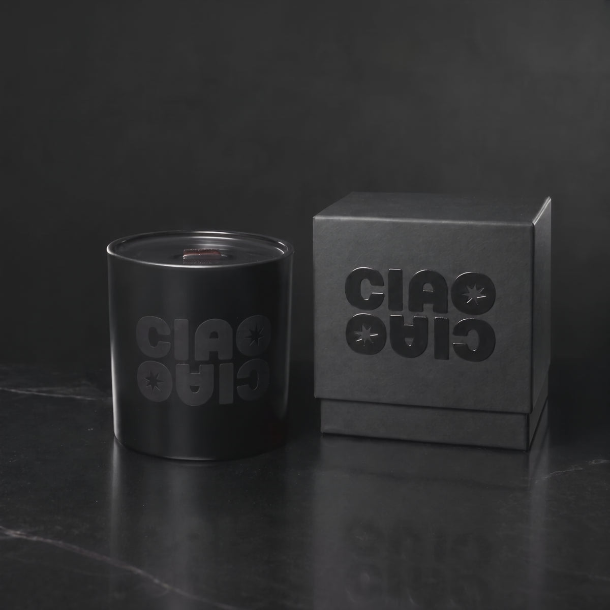 Matte Black 14 oz. Luxury Printed Candle with a tone-on-tone CIAO CIAO logo, lit.