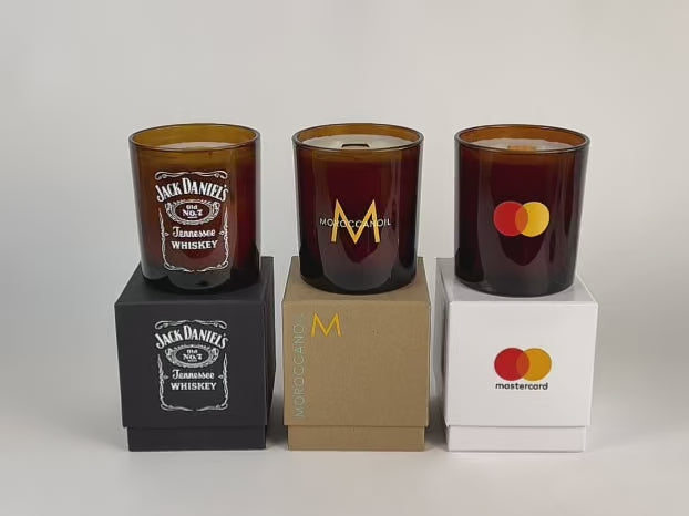 video showcase of candle lighting of 3 amber 14 oz candles on top of their respective gift box, all in a row