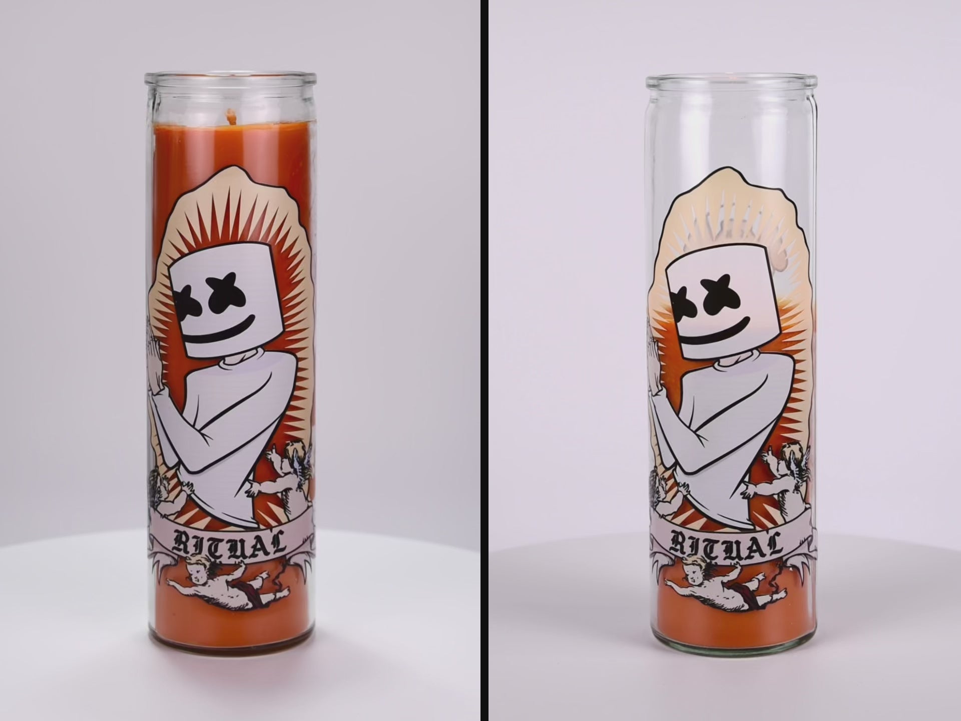 Load video: Two 16 oz Prayer Candles from Custom Candles LA filled with orange wax in a tall glass container spinning side by side. The candles are printed with an image of a person praying. The head of the person is marshmallow shaped with black Xs as eyes and a smile. Below the person there is a banner that reads &quot;RITUAL&quot; and the person is surrounded by three cherubs. There is a spikey border around the artwork and the orange wax shows through. 
