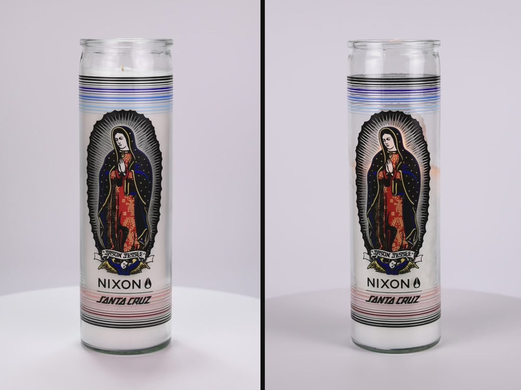 Two 16 oz Prayer Candles from Custom Candles LA filled with white wax in a tall glass container spinning side by side. The candles are printed with a colorful image of a saint named "JASON JESSEE". Beneath the saint is a logo that reads "NIXON SANTA CRUZ" printed in black. Behind the saint imagery are horizontal lines surrounding the candle in black, blues, and reds. The white wax shows through the glass.