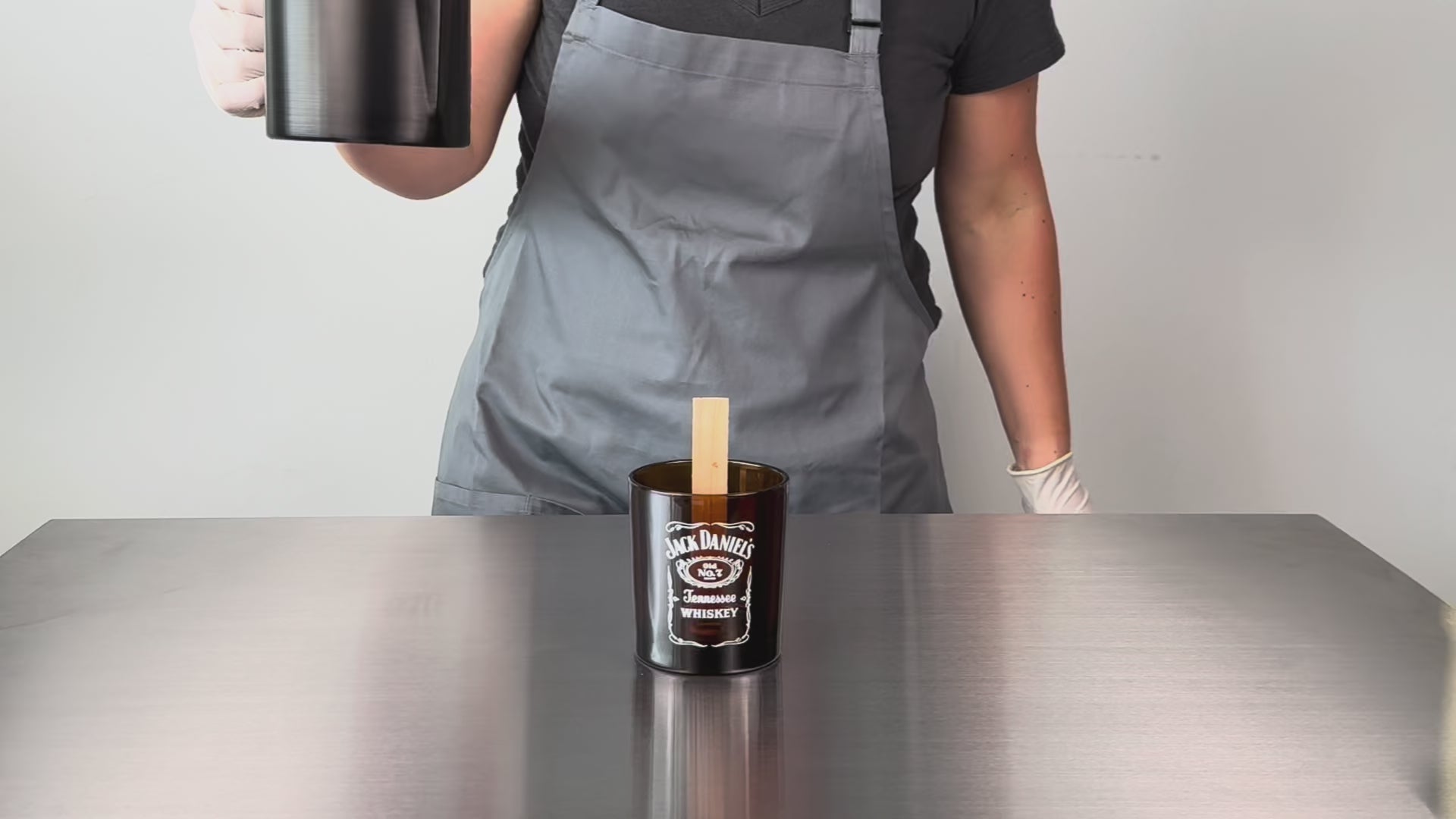 Load video: wide shot example video of wax pouring into a printed amber glass candle
