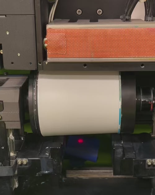 Load video: example of high speed rotational direct to surface printing process onto white glass candle vessels