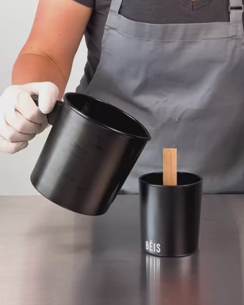 Load video: close up example video of wax pouring into a printed black glass candle