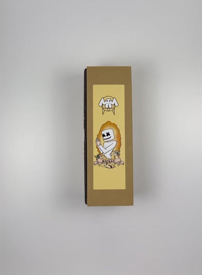 An unboxing video of the 16 oz Prayer Candle from Custom Candles LA filled with orange wax that comes in a Kraft mailer box with a yellow sticker label of the logo artwork. The candle is printed with an image of a person praying. The head of the person is marshmallow shaped with black Xs as eyes and a smile. Below the person there is a banner that reads "RITUAL" and the person is surrounded by three cherubs. There is a spikey border around the artwork and the orange wax shows through. 