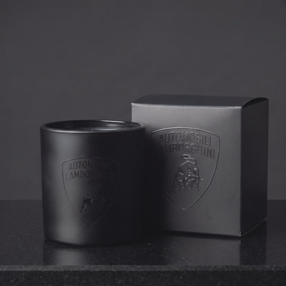 Video of a custom printed 9 oz matte black candle with a gloss black logo catching the light beside its branded gift box, made in Los Angeles by Custom Candles LA