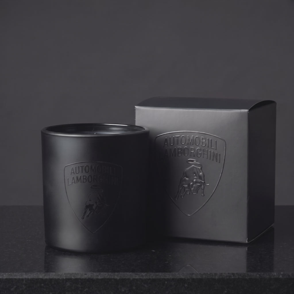 Video of a custom printed 9 oz matte black candle with a gloss black logo catching the light beside its branded gift box, made in Los Angeles by Custom Candles LA