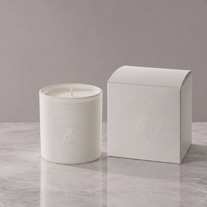 Matte white 9 oz. Classic Candle lit, with a tone-on-tone Lamborghini shield logo glowing beside its white gift box, made in Los Angeles by Custom Candles LA